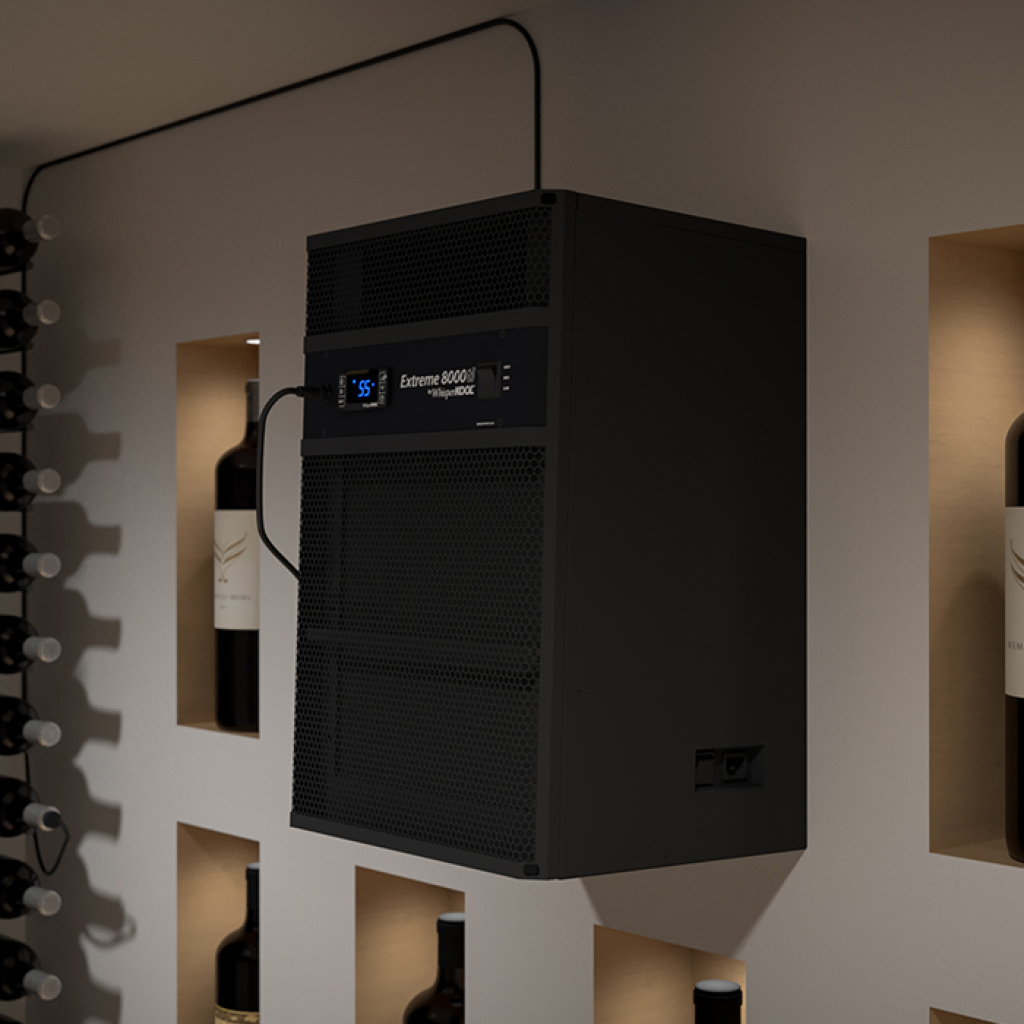 A WhisperKOOL Extreme 8000ti wine cellar cooling unit in black is wall-mounted above shelves of wine bottles, with a digital temperature display visible.