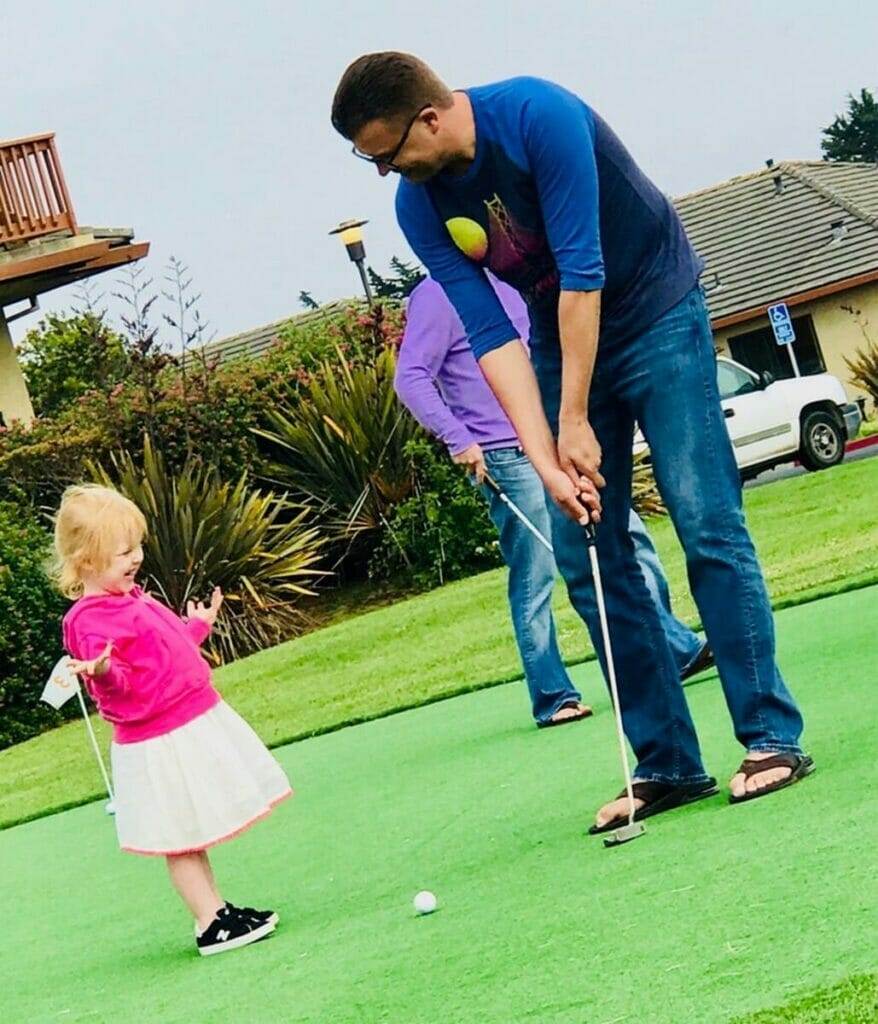 Man, little girl, golf.