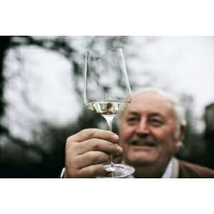 An elderly gentleman showcasing a Zalto - Bordeaux Wine Glass.