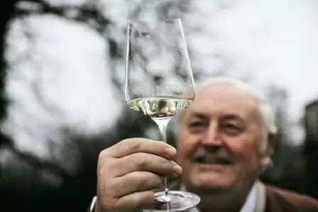 An elderly gentleman showcasing a Zalto - Bordeaux Wine Glass.