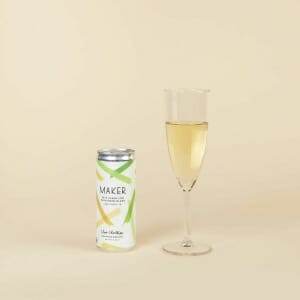 A glass of Maker Wine Sparkling Sauvignon Blanc by Chris Christensen next to a can of lemonade.