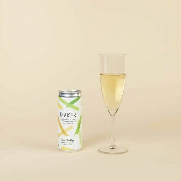 A glass of Maker Wine Sparkling Sauvignon Blanc by Chris Christensen next to a can of lemonade.