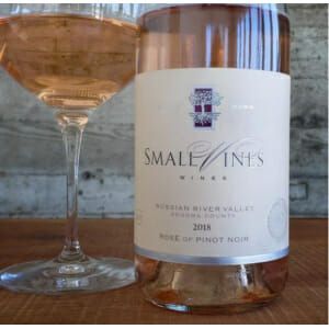 A glass of 2018 Small Vines Russian River Valley Rose of Pinot Noir on a wooden table.