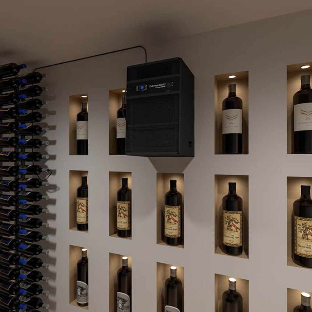 A wall-mounted wine cellar cooling unit installed above illuminated wine bottle cubbies, with additional bottles stored in a vertical rack on the left.