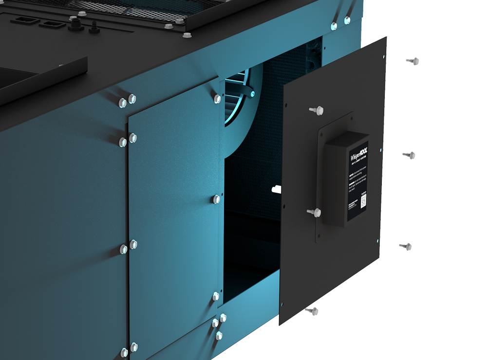 A black access panel on industrial equipment is open, revealing the internal components and a blower fan of the Whisperkool 8000. Loose screws are scattered around the panel.