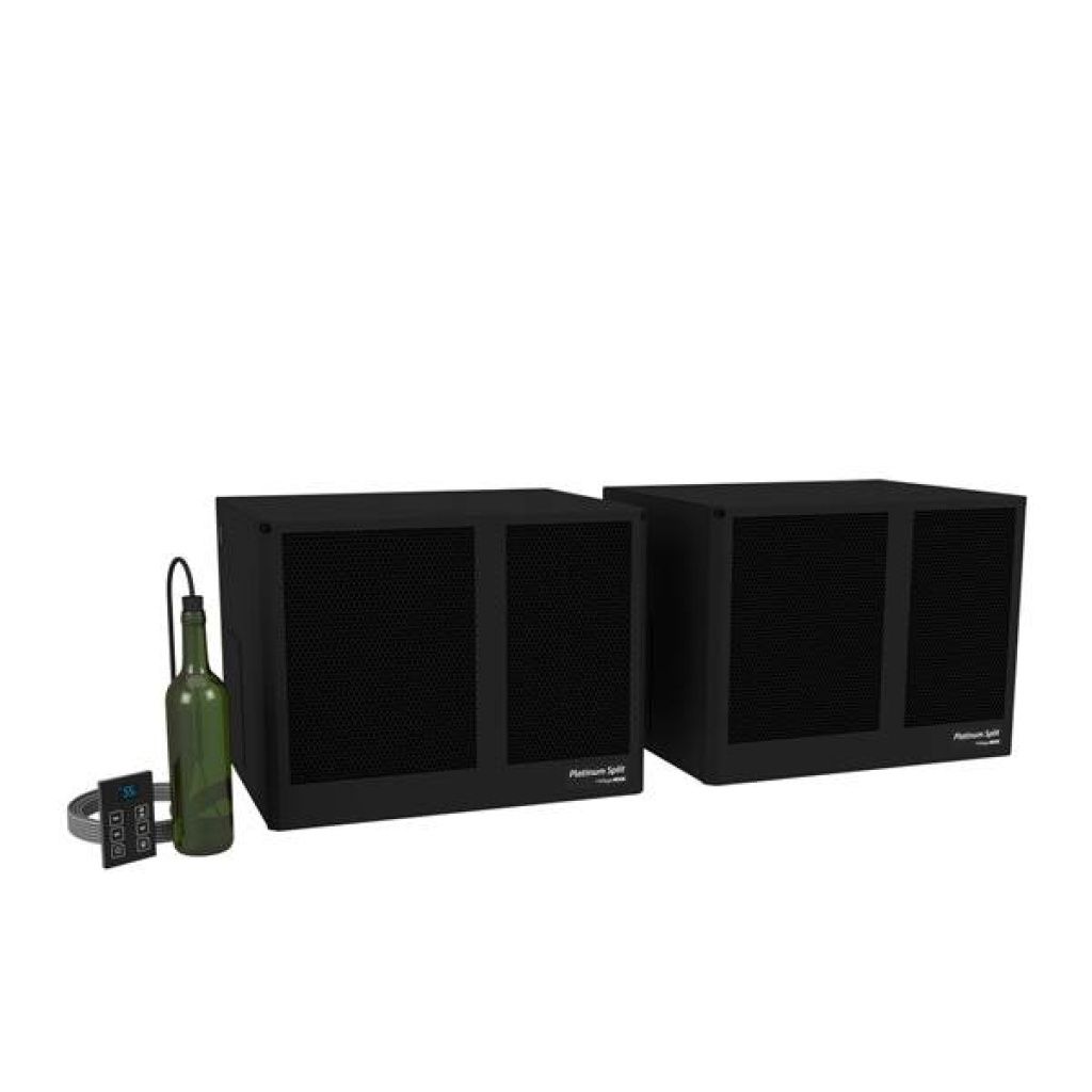 Two black loudspeakers are placed side by side. A green bottle and a small control panel with a display and buttons are positioned next to the speakers.