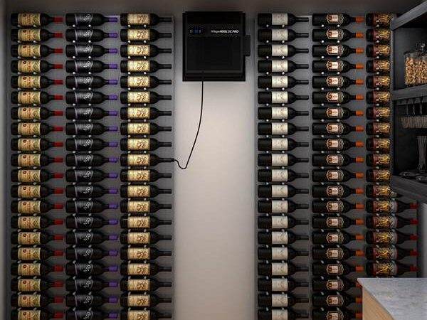 A wine cellar features wine bottles neatly stored on wall-mounted racks, with a small cooling unit centered on the back wall.