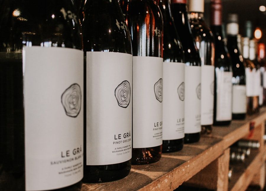 A row of wine bottles with white labels on a wooden shelf in a store.