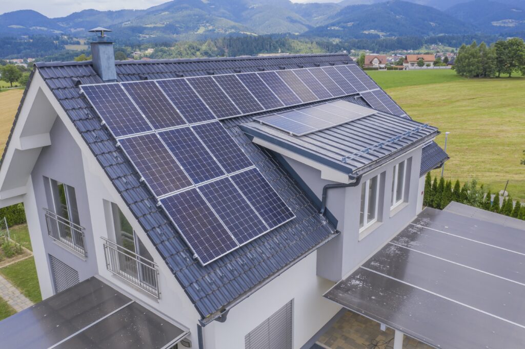 House with multiple solar panels installed on the roof, set in a rural Sonoma County area with fields, mountains, and even a private wine cellar in the background.