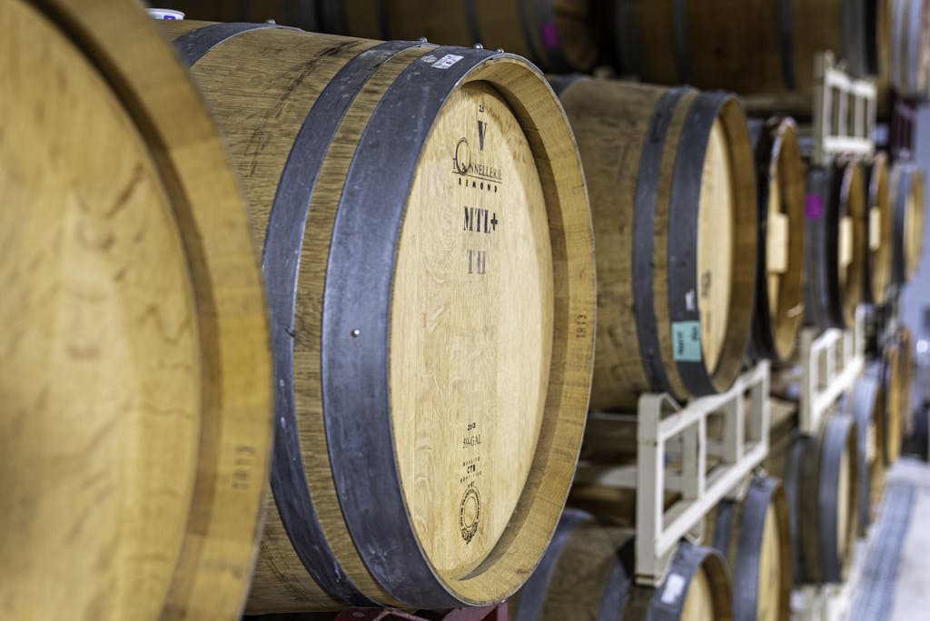 A row of wooden wine barrels in a North Carolina winery storage area, showcasing craftsmanship and tradition.