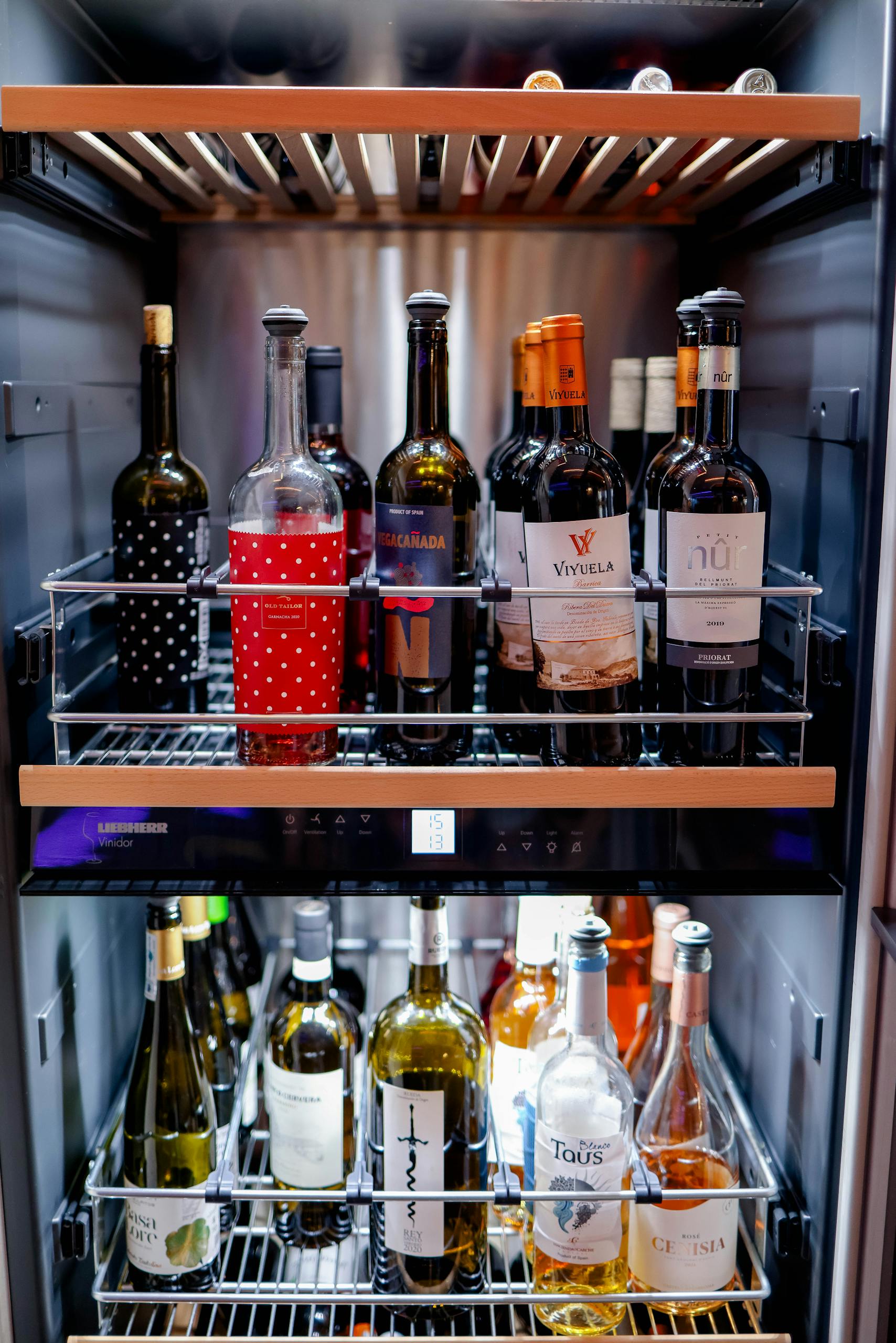 A variety of wine bottles elegantly displayed inside a sleek wine refrigerator, perfect for any wine enthusiast.
